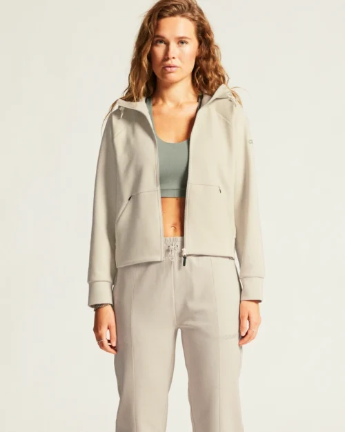 Poseeraava nainen beigen värisessä hupparissa