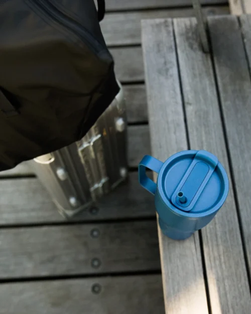 Pillillinen termosmuki harmaan terassin portaan päällä